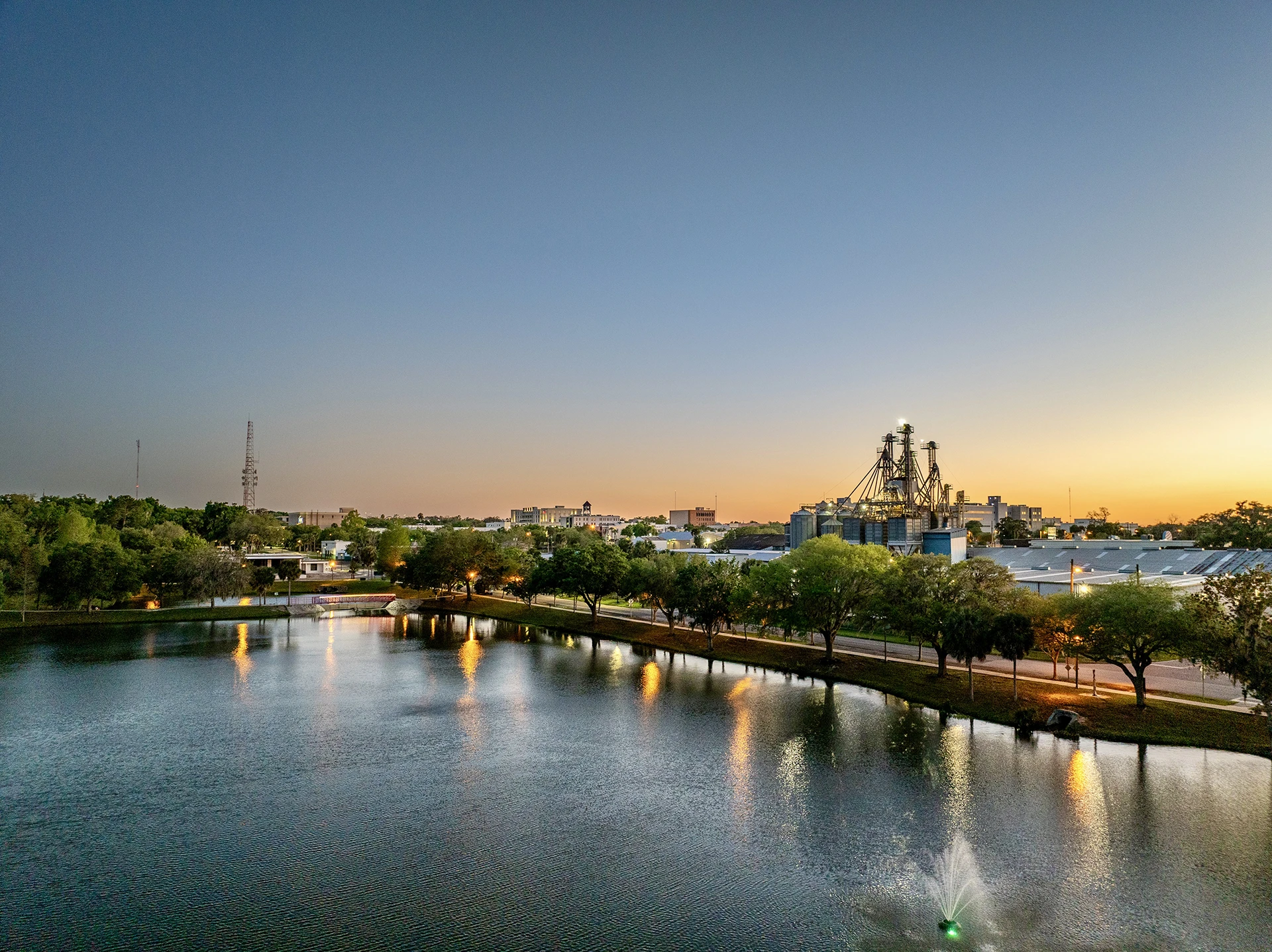 Ocala cityscape beyond a waterfront park beneath a warm Central Florida sunset.